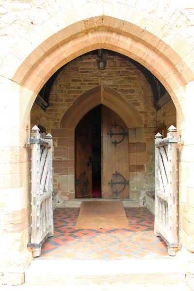 The porch of the church with a door open to the inside