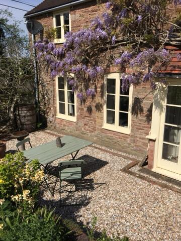 Stone house covered in purple wisteria