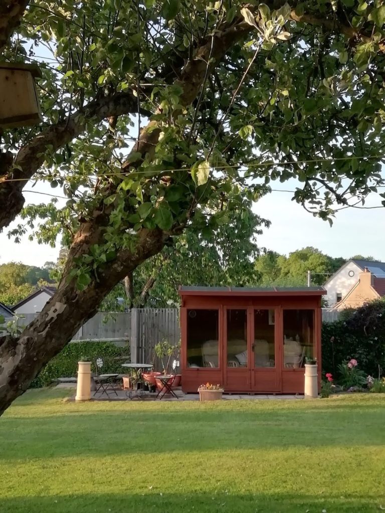 A garden with a summerhouse and a tree