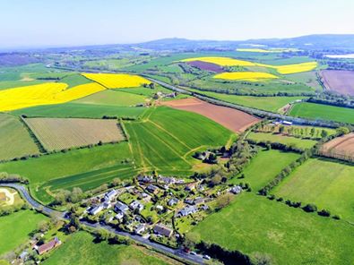 Aerial view of the village showing houses surrounded by green fields