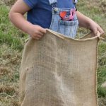 child in blue taking part in a sack race