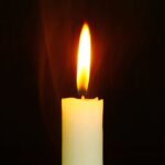 Cream candle with an orange flame