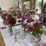 Bunches of brightly coloured flowers in vases on a table