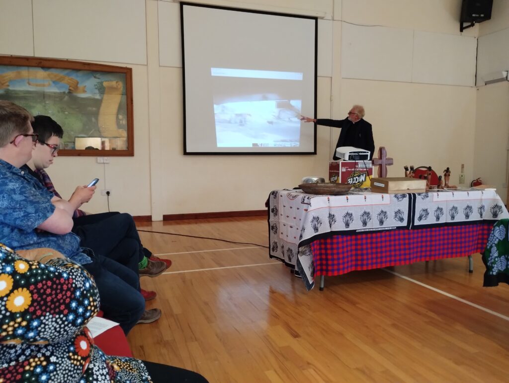 vicar pointing at a slide on a screen in the millennium hall