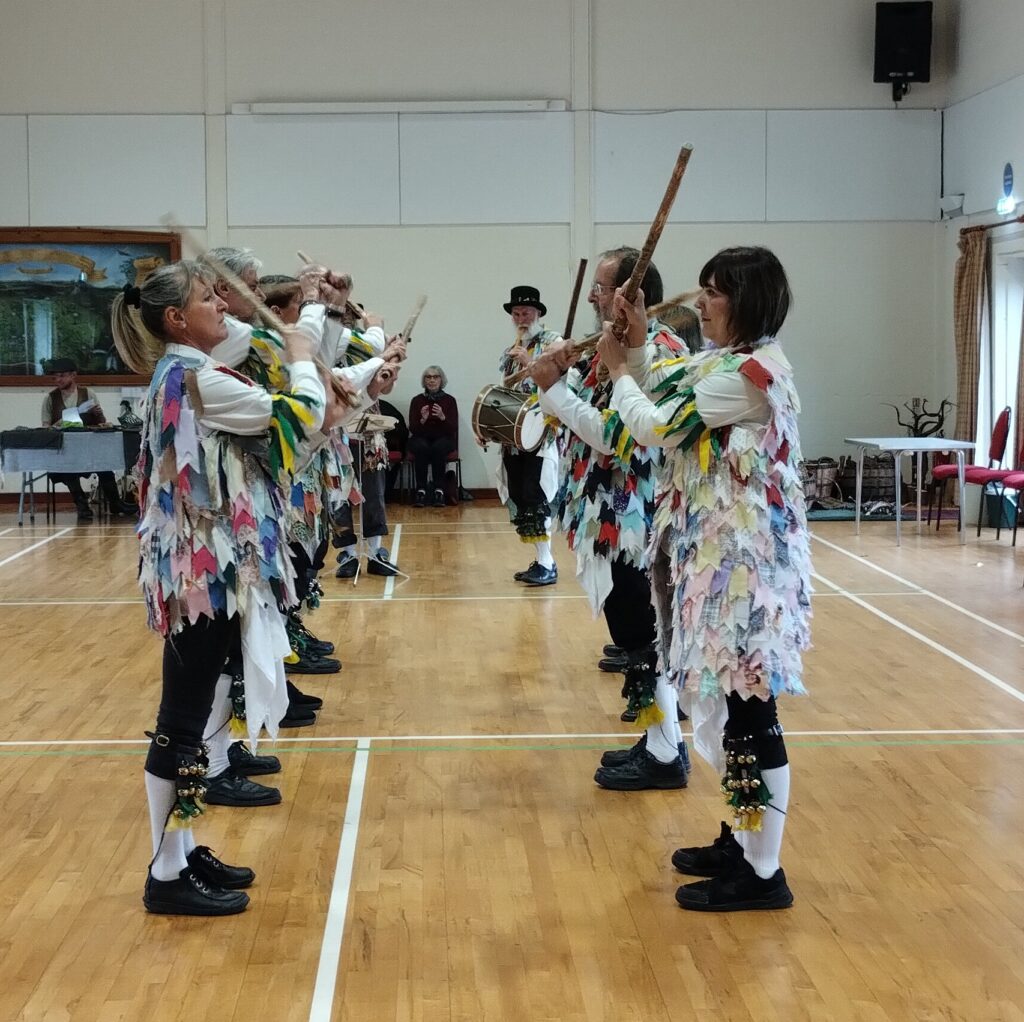 a group of Morris dancers in multicoloured costumes