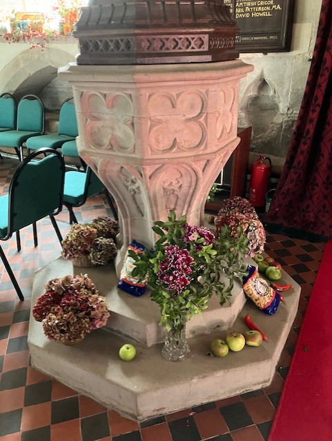 church font decorated with flowers and apples