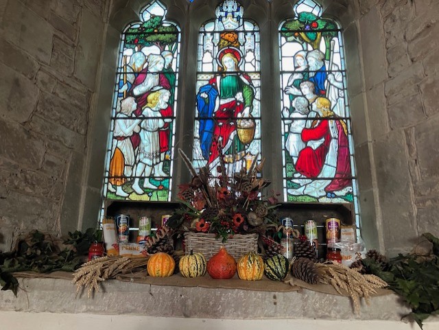 autumn flowers in front of stained glass window