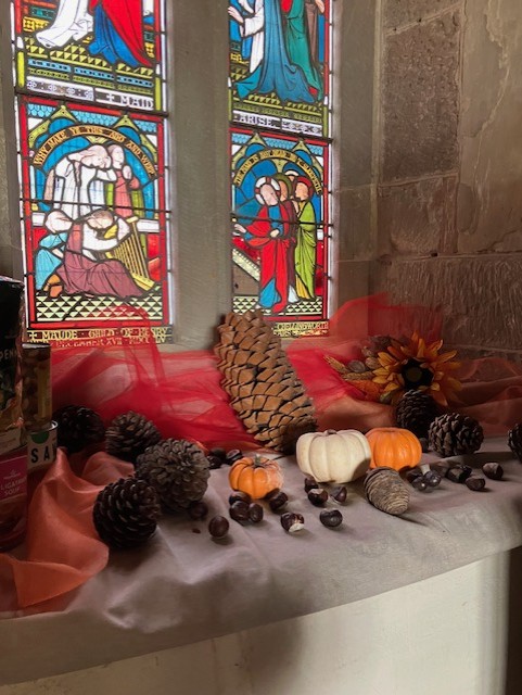 pumpkins in front of a stained glass window