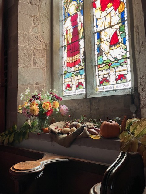 autumn flowers in front of stained glass window