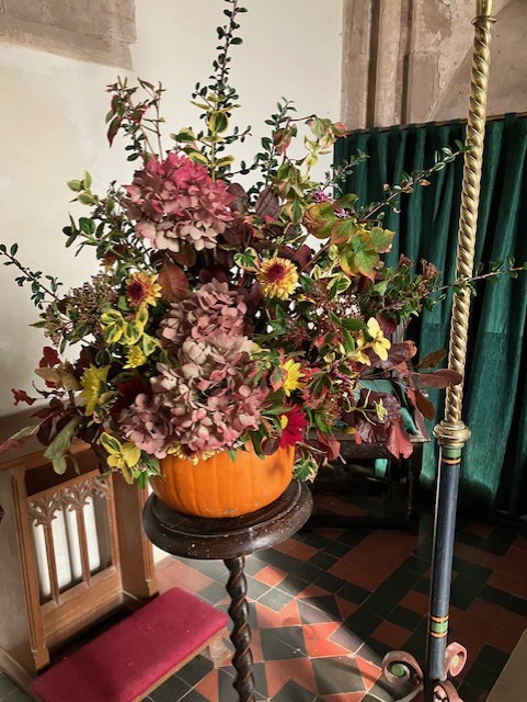 yellow and pink flowers in a pumpkin vase