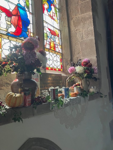 autumn flowers in front of stained glass window