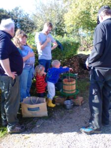 Four adults and two children using an applk e press